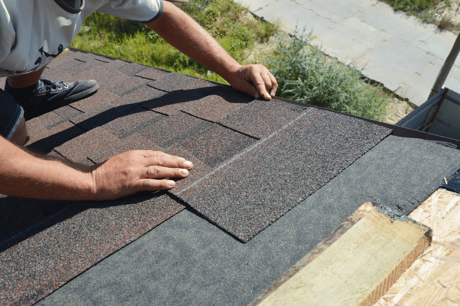 roofer putting up asphalt shingles on a home 