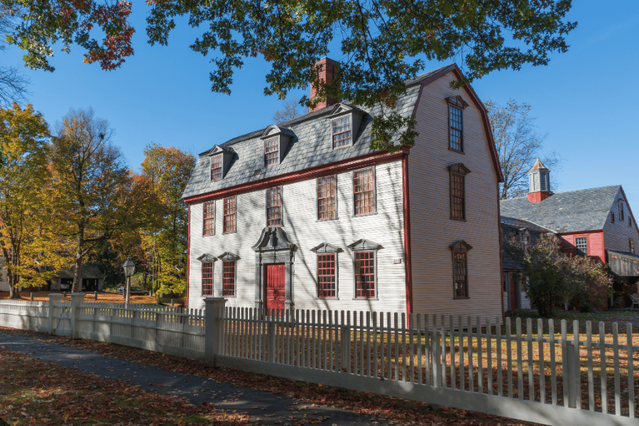 Historic Colonial Home during fall with colorful leaves and red front door