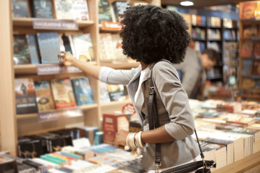 woman in a bookstore looking for a new book on a shelf