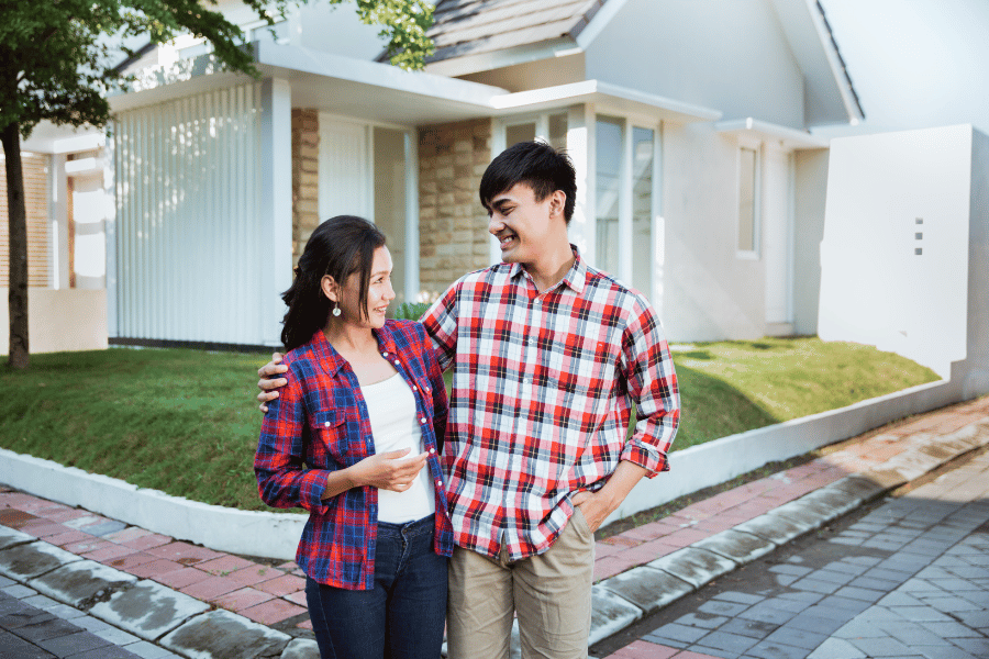 couple standing in front of their newly bought home