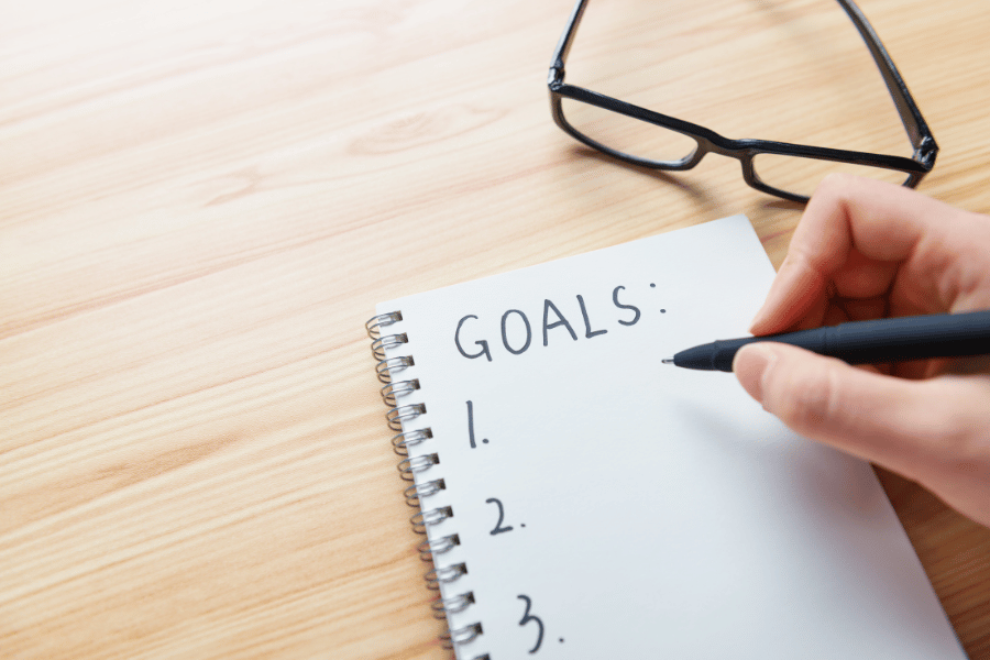 writing down and setting goals on a notepad 