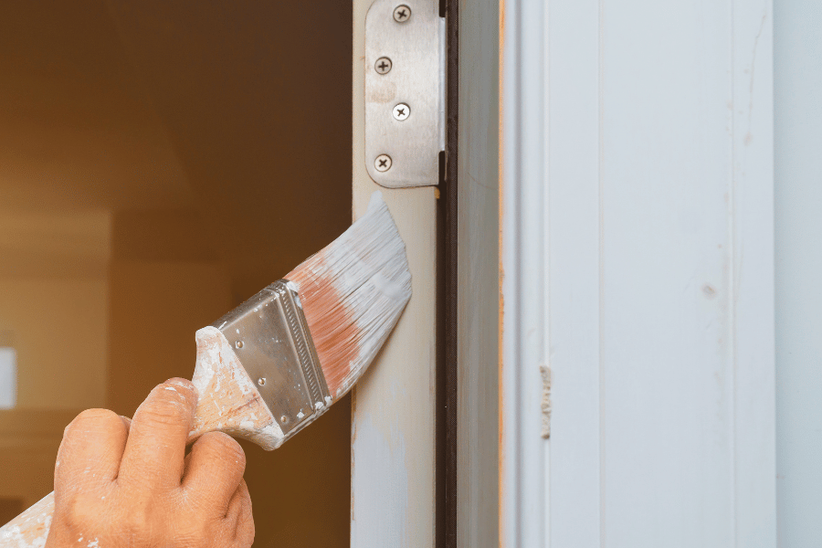 Painting the edge of front door with a big paint brush