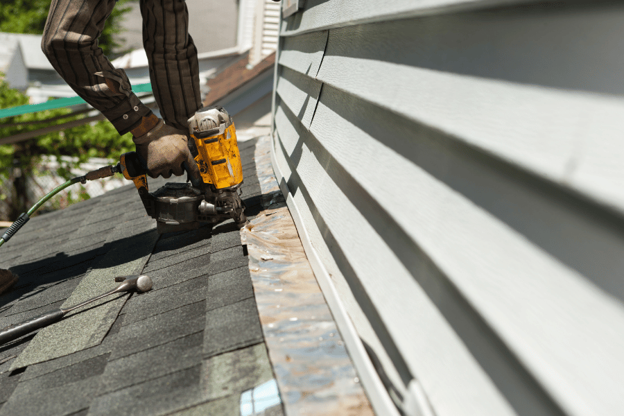Replacing the roof on a home with a nail gun 