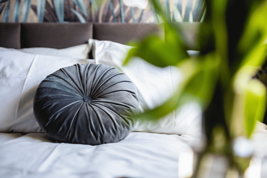 Round pillow on the bed of a staged home 